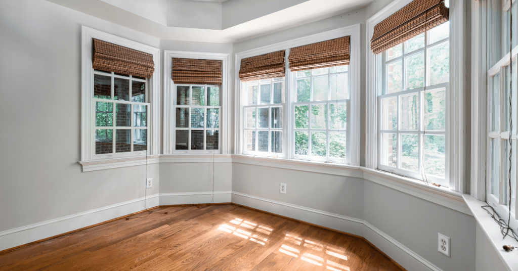a serene living room with large windows with blinds